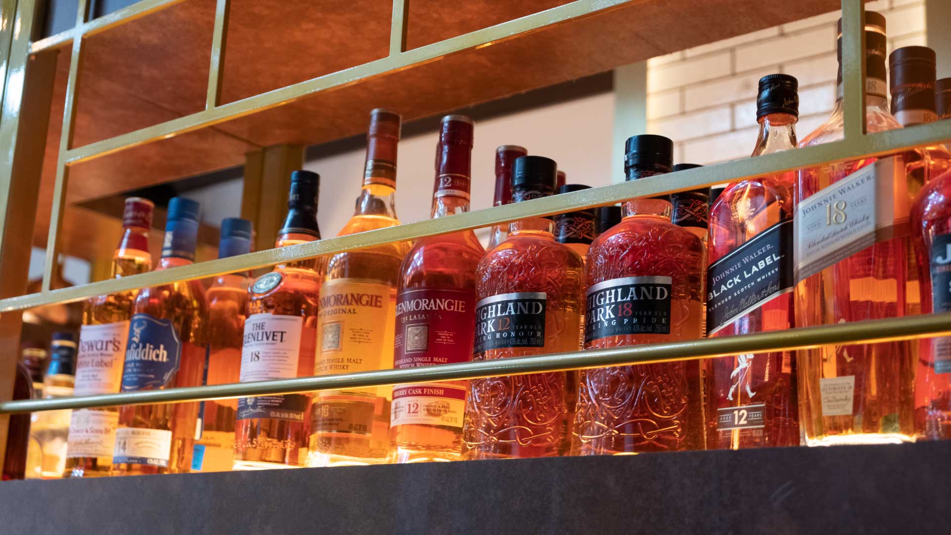 Multiple brands and bottles of whiskey displayed on a shelf