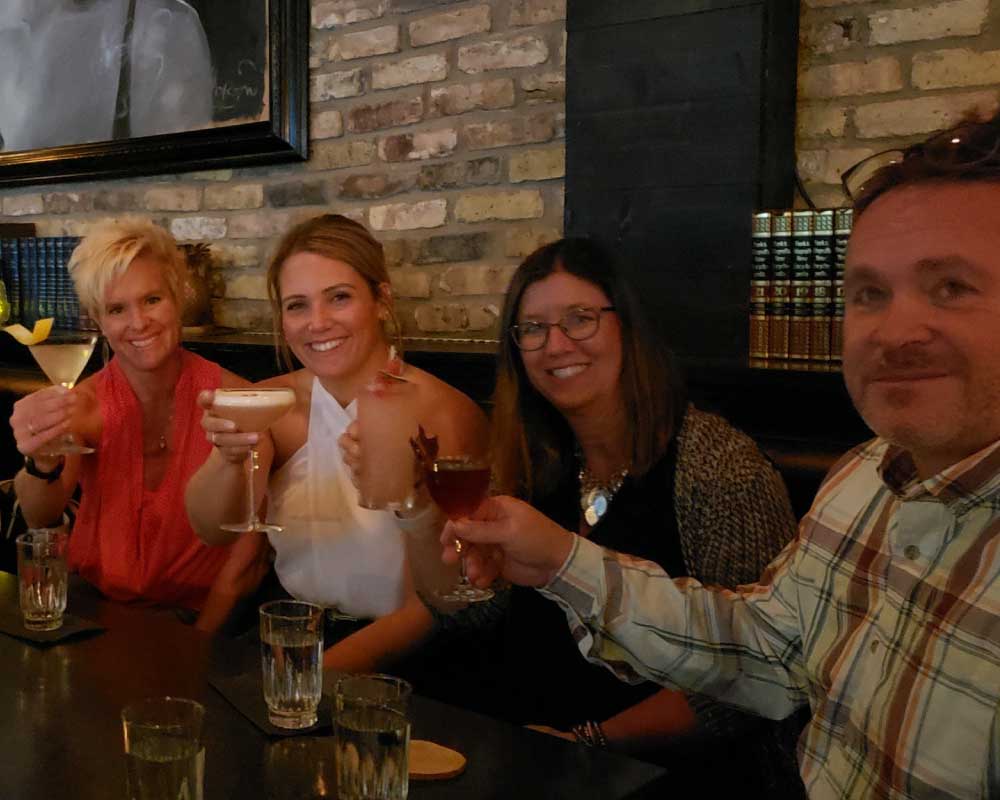 Group of smiling rockers giving a toast with drinks