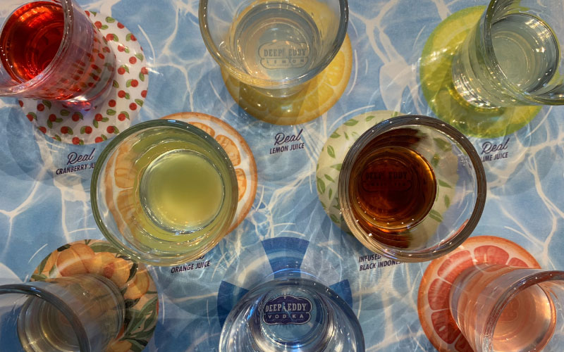 Multiple glasses with different color drink mixes with Vodka