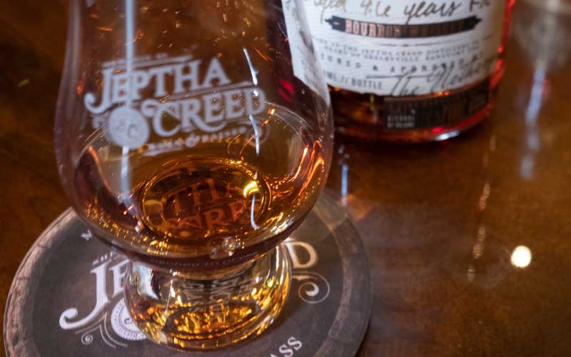 Close up picture of glass with bourbon in it